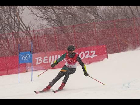 Benjamin Alexander, of Jamaica passes a gate during the first run of the men’s giant slalom at the 2022 Winter Olympics, Sunday, Feb. 13, 2022, in the Yanqing district of Beijing. 
