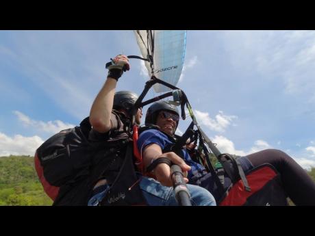 Gleaner reporter Asha Wilks on her first paragliding experience with veteran paragliding pilot Ingo Hillman, co-owner of Paradise Wings, on April 30. The pair took off from a section of Skyline Drive in St Andrew and landed at Papine High School.