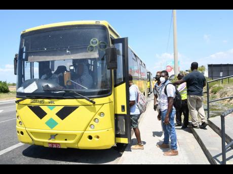 In this 2020 photo commuters are seen getting on to a JUTC bus in Portmore.