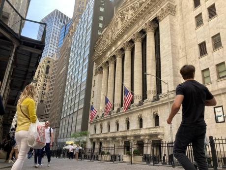 AP 
Pedestrians walk by the New York Stock Exchange on Wednesday, May 18, in New York.