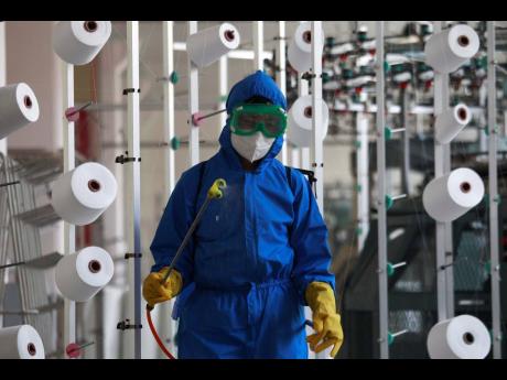 An employee of Songyo Knitwear Factory in Songyo district disinfects the work floor in Pyongyang, North Korea, Wednesday, after the country’s leader Kim Jong Un said Tuesday his party would treat the country’s coronavirus outbreak under the state emerg