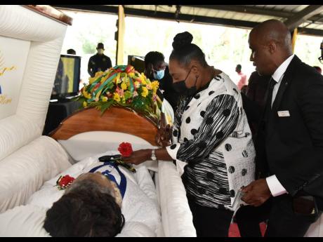  Minister of Culture, Gender, Entertainment and Sport. Olivia Grange, lays a single red rose on the body of her dear friend, Tabby Diamond. Standing next to her is Peter Perry, CEO of Perry’s Funeral Home. 