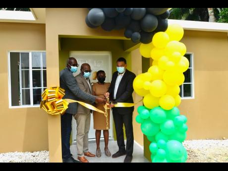Prime Minister Andrew Holness (right) is joined by (from left) Uvel Graham, councillor for the Spring Mount Division in St James, and St James East Central Member of Parliament Edmund Bartlett in cutting the ribbon with Beverly Thompson as the Government h