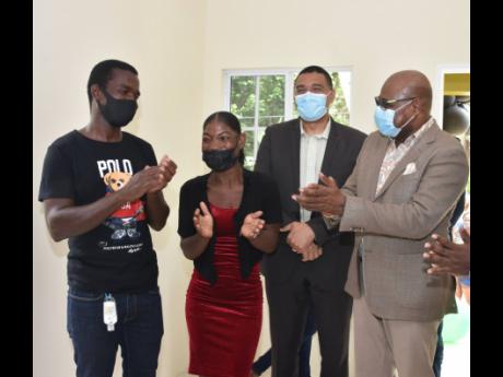 From left: Jermaine Clarke and his wife, Jasseth, smile broadly behind their masks as Prime Minister Andrew Holness and St James East Central Member of Parliament Edmund Bartlett join in celebrating the handing over of a new home to them in Lottery, St Jam