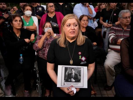 
Attorney General Sandra Quinonez, holding an image of the late anti-drug prosecutor Marcelo Pecci, attends a meeting to demand justice over his murder, in Asuncion, Paragua