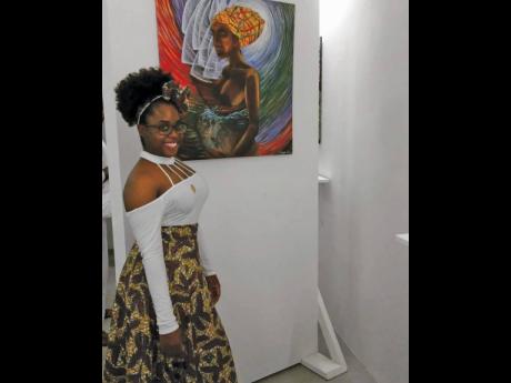 
Junette Alexander poses with one of her painting