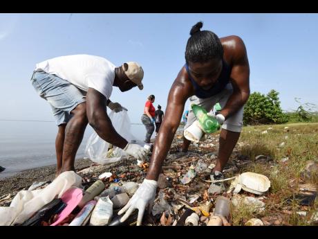 Volunteers from Jamaica National Group turn out at Sirgany Beach in east Kingston to clear the coastline of garbage for a pre-Labour Day project. 