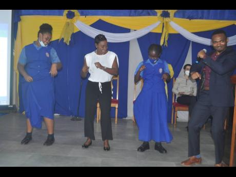 State Minister Juliet Cuthbert-Flynn (second left) takes up the challenge given by students Shanna-Kay Vernal (left) and Rander Duhaney (right) to do the ‘Dirt’ dance. Looking on is Alexander Shaw, president of the past students’ association. 