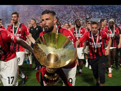 AC Milan’s players, including Olivier Giroud (centre), celebrate after winning the Serie A title yesterday.  It is AC Milan’s first Serie A title in 11 years.