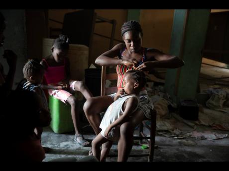 A woman braids a girl’s hair at a school converted into a shelter after they were forced to leave their homes because of clashes between armed gangs in the Tabarre neighbourhood of Port-au-Prince, Haiti, on May 12. UNICEF’s representative in Haiti said