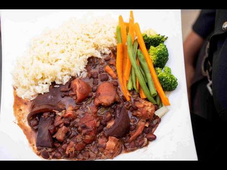 Her famous ‘tie me’ stew peas, made with cow skin and chicken foot, is paired perfectly with white rice, accompanied by steamed vegetables on the side.