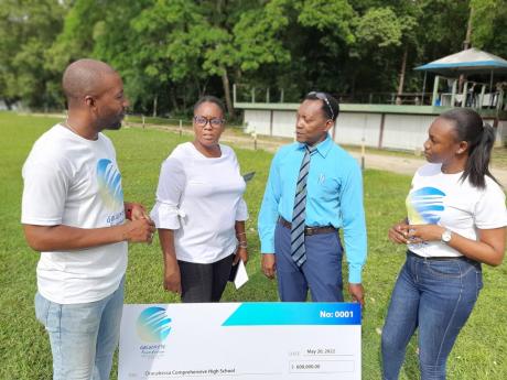  From left: Travis Graham, manager at Golden Eye Foundation, speaks with principal at Oracabessa High School, Natrecia Whyte-Lothian, senior vice-principal Donovan Thomas, and Shavel Lawrence of the foundation, at James Bond Beach after presenting a cheque