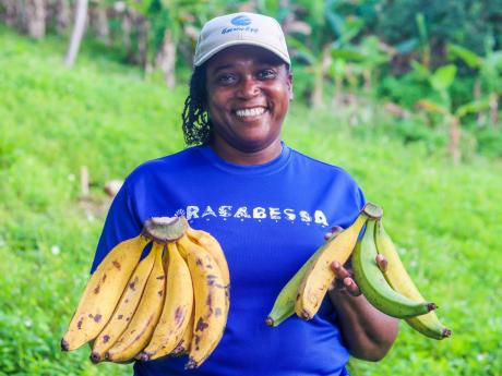  Margaret, a first-round SLGT beneficiary, shows off plantains from her farm. 