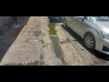 A stream of Smelly, discoloured water runs in a drain along William Street in Port Antonio. The widespread practice is causing an unbearable stench in the town.