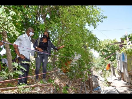 Local Government Minister Desmond McKenzie and St Andrew East Rural Member of Parliament Juliet Holness discuss the concerns in the Harbour Drive area, where residents are appealing for the inadequate drainage system to be addressed as it puts their proper