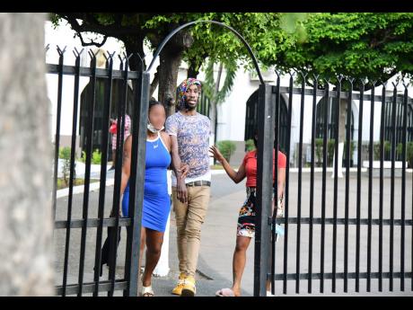 Rivaldo Hylton is accompanied by two women after being released. He had been charged with being a member of the One Don Gang.