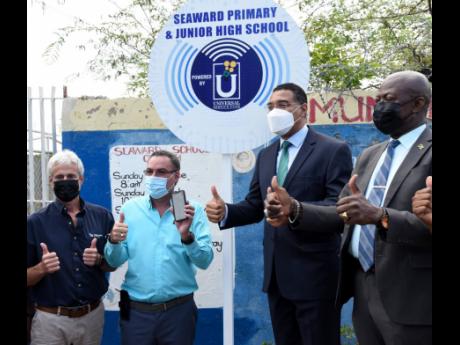 Prime Minister Andrew Holness (second right), Bruce Bicknell (left), manager, Tankweld Metals; Daryl Vaz (second left), minister of science, energy and technology and Daniel Dawes, CEO, Universal Service Fund, gives the thumbs up to the public Wi-Fi at Sea