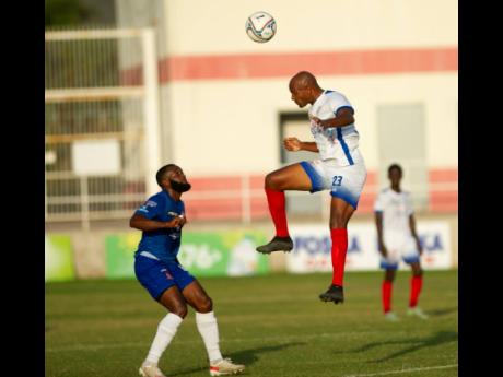 
Dunbeholden’s Fabian McArthy (left) looks on while Portmore United’s Rudolph Austin heads the ball away during a Jamaica Premier league encounter at Sabina Park on Monday, March 14, 2022.