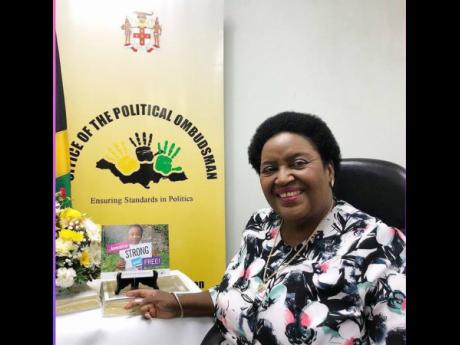 
Political Ombudsman, Donna Parchment Brown in her office with the cover of ‘Jamaica Strong and Free: A Civic Education Handbook’.