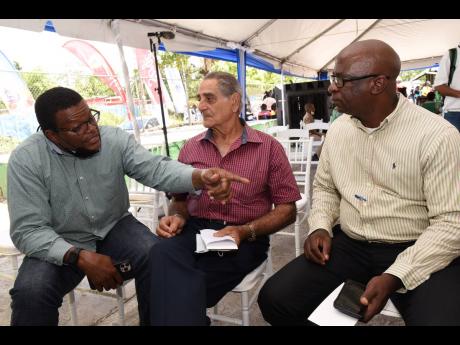 From left: Dr Derrick Deslandes, chairman, Jamaica Dairy Development Board (JDDB), talks about milk production with dairy farmer Adeeb Azan and Orville Palmer, chief technical director in the Ministry of Agriculture, during a World Mild Day event at Tulloc