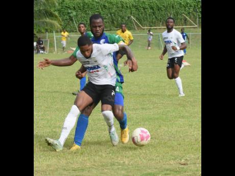 Cavalier SC’s Ronaldo Webster shields the ball from Montego Bay United’s Giovannie Reid during a Jamaica Premier League match at Westpow Park on Wednesday.