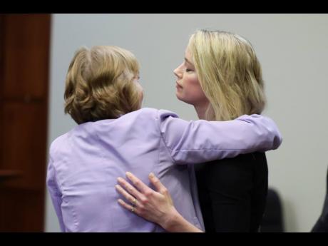 Actor Amber Heard (right) hugs her lawyer Elaine Bredehoft after the verdict was read at the Fairfax County Circuit Courthouse in Fairfax, Virginia, on Wednesday. 