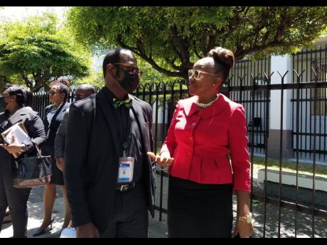 Corporal Rohan James, chairman of the Jamaica Police Federation, in dialogue with General Secretary Arleen McBean following yesterday’s Supreme Court ruling in the federation’s overtime wage dispute with the Government.