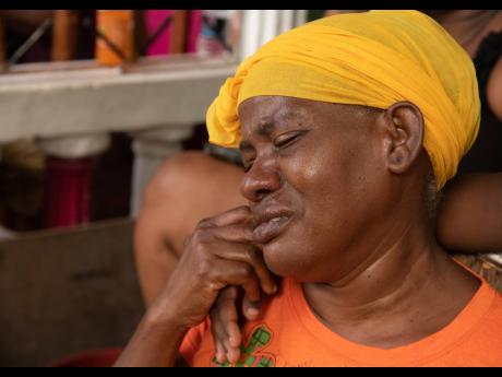 Marva Vernon-Jackson grieves the shooting deaths of her husband, Raymond Jackson; nephew Orville Hermit; as well as Kevon Bonfield, in Pleasant View Lane in Eight Miles, St Andrew, on Sunday.