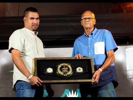 David Harper (left) shares a memorable moment with his father, Noel ‘Papa Jaro’ Harper, founder of the legendary Killamanjaro Sound System, as he supports him on stage to collect the Guinness Sounds of Greatness Recognition Award for the sound’s cont