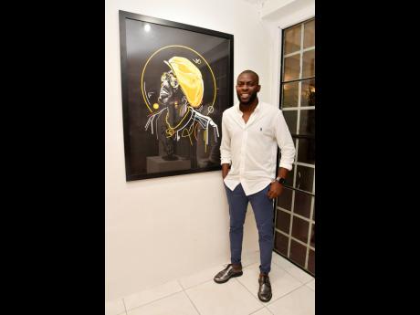 Jowaine Graham poses for a photo with his artwork titled ‘The Yellow Hat’ at The Harder They Come Exhibit Opening and Concert.