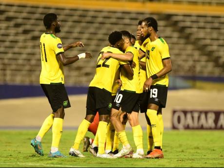 Reggae Boyz celebrate one of the three goals they scored against Suriname inside the National Stadium yesterday during National League A action.