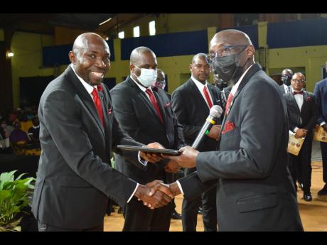 Pastor Rabbi Brown (left) receives his certificate of ordination from Pastor Adlai Blythe, treasurer of the Jamaica Union Conference, while pastors Dane Morgan (second left) and Maurice McGhie look on.