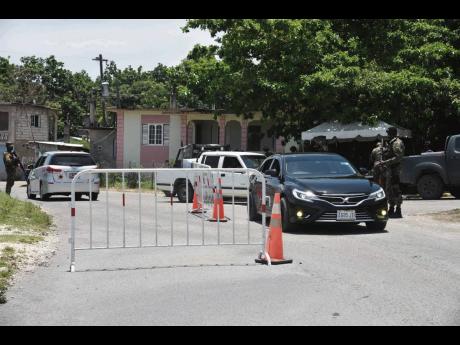 Soldiers manning the checkpoint at the entrance of Paradise, Norwood, in St James. 