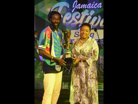Buju Banton is presented with the Jamaica Festival Song Competition trophy by Olivia ‘Babsy’ Grange after winning the 2020 competition. 