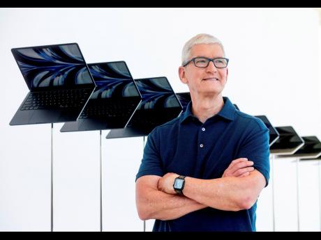 Apple CEO Tim Cook stands in front of a display of new Apple MacBook Air computers with M2 processors on June 6, 2022.