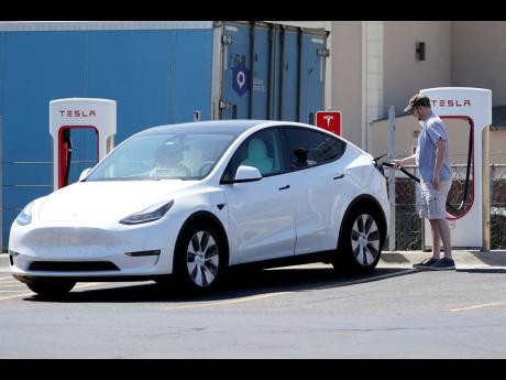 A Tesla owner charges his vehicle at a charging station in Kansas.