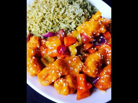 Sesame seed sweet and sour pineapple chicken, served with callaloo rice. 