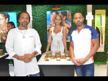 Kadejah Anderson, brand manager, Epican, shows off some of the new strains as Dwayne McKenzie, president of Epican (left) and Karibe McKenzie, CEO, look on.