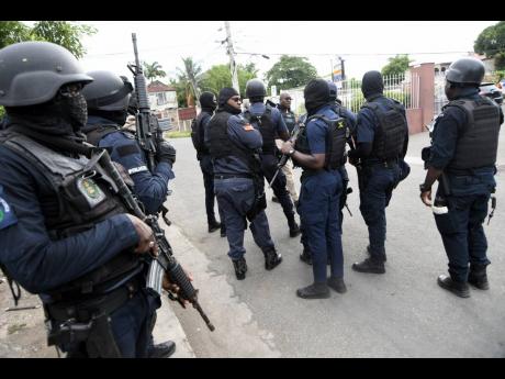 Policemen swarm French and William streets where an alleged gunman was killed in Spanish Town. Two others were slain by gang assailants in the market district.
