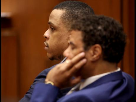 Defendant Eric Holder (right) and his attorney, Aaron Jansen, listen during opening statements in Holder’s murder trial, in this June 15 file photograph. 