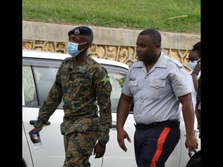 Jamaica Defence Force Private Kishawn Henry Sr, father of the slain 23-month-old infant, arrives on the crime scene in Cocoa Piece with his brother Adrian Henry.