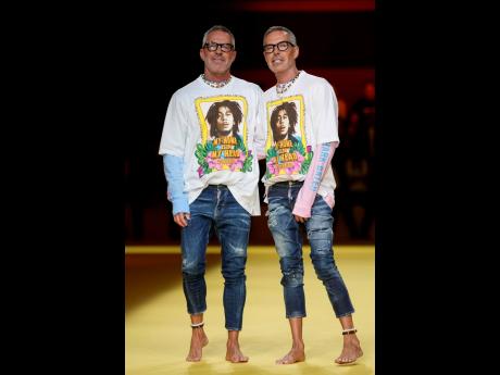 Designers Dean Caten (left) and Dan Caten accept applause at the end of the Dsquared2 men’s Spring/Summer 2023 collection presented in Milan, Italy, while donning Bob Marley-emblazoned T-shirts.