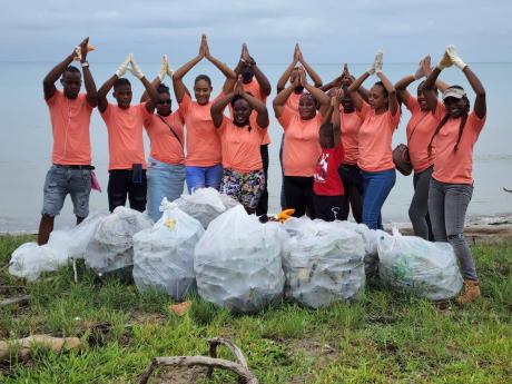 The Margaritaville team celebrate their plastic bottle find during the beach clean-up last Saturday in Montego Bay. 