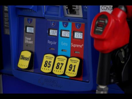 FILE - In this May 9, 2021, file photo prices are illuminated above the levers for the different grades of gasoline available at a pump at an Exxon station in Littleton, Colo. Congressional Democrats are calling top executives at ExxonMobil and other oil g