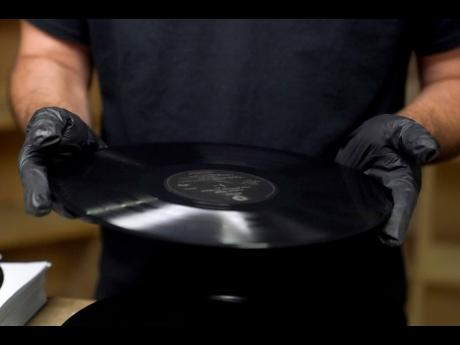 Ricky Riehl inspects finished vinyl records for physical flaws before they are packaged.