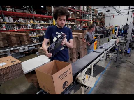 Elijah Lindsay loads finished vinyl records into shipping boxes at the United Record Pressing facility. Vinyl record manufacturers are rapidly rebuilding an industry to keep pace with sales that topped US$1 billion last year. 