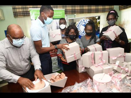 Derrick Bernard (second left), student at Hillel Academy, donates breast prostheses and brassieres to breast cancer survivors (from third left) Eulalee Callum, Hygena Reid, Paula Headlam, and Leonie Jackson, while Michael Leslie (left), acting executive di
