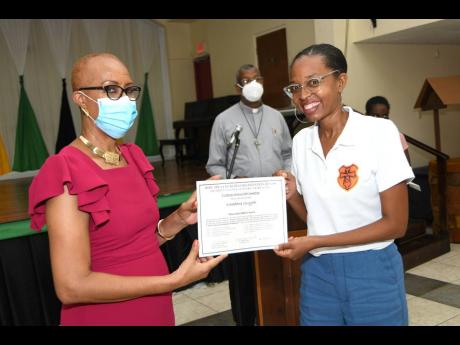 Fayval Williams (left), minister of education and youth, presents certificate to Khadene Guyah, one of the trainers at the Hope Area Churches Organisation (HACO) Values and Attitudes ‘Train-the-Trainers’, course at an awards ceremony at Sts Peter and P