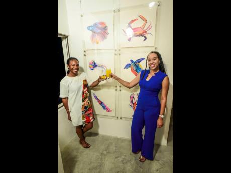 Cheering to a successful night are director of Sky Gallery Tara Brown (left) and Amashika Lorne, PSOJ marketing and PR manager, who moderated the Artsy Mingle.