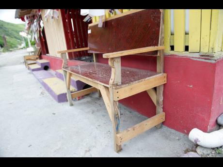 Empty benches are seen outside the bar operated by Valerie Dixon in Grants Pen, which has turned into a ghost town since the opening of a segment of the under-construction highway rerouted traffic from the St Thomas fishing village. 
